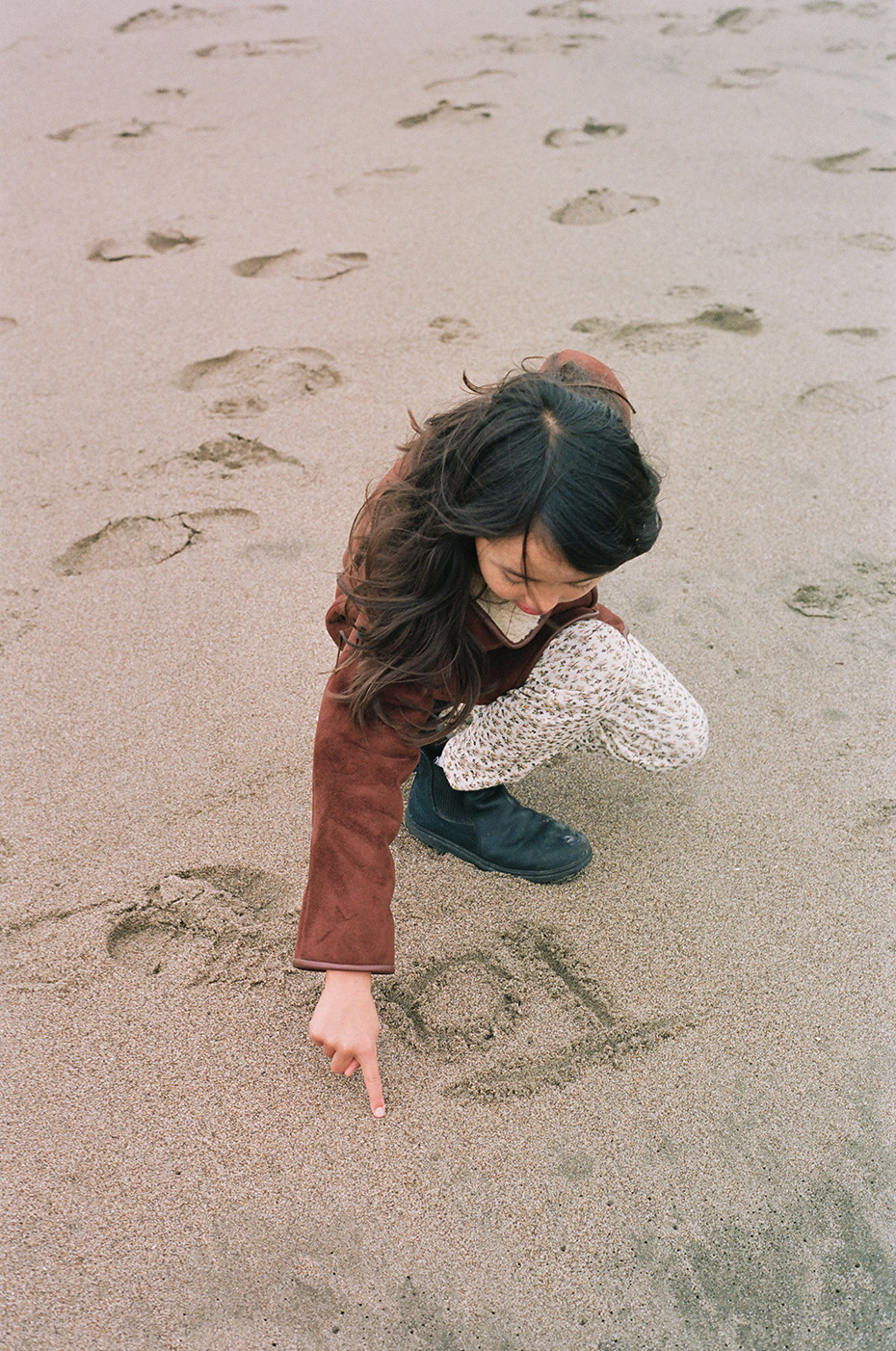 Tallie writing in the sand  for Doen Journal. 35mm. Sunset Beach, San Francisco CA 2023.